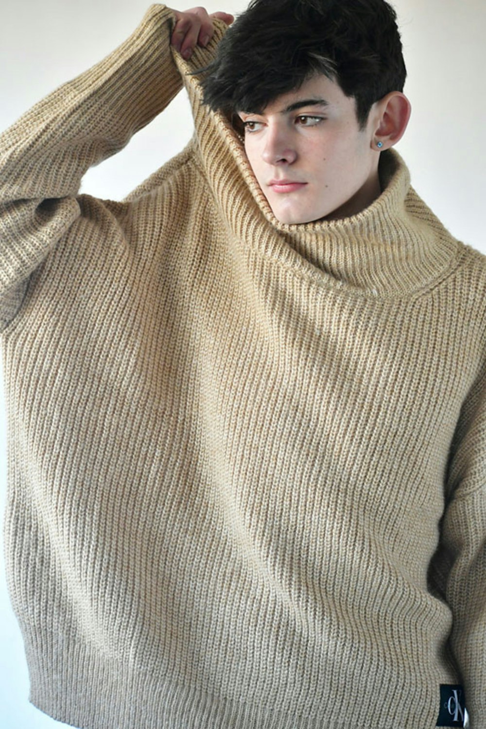 a young man wearing a turtle neck sweater