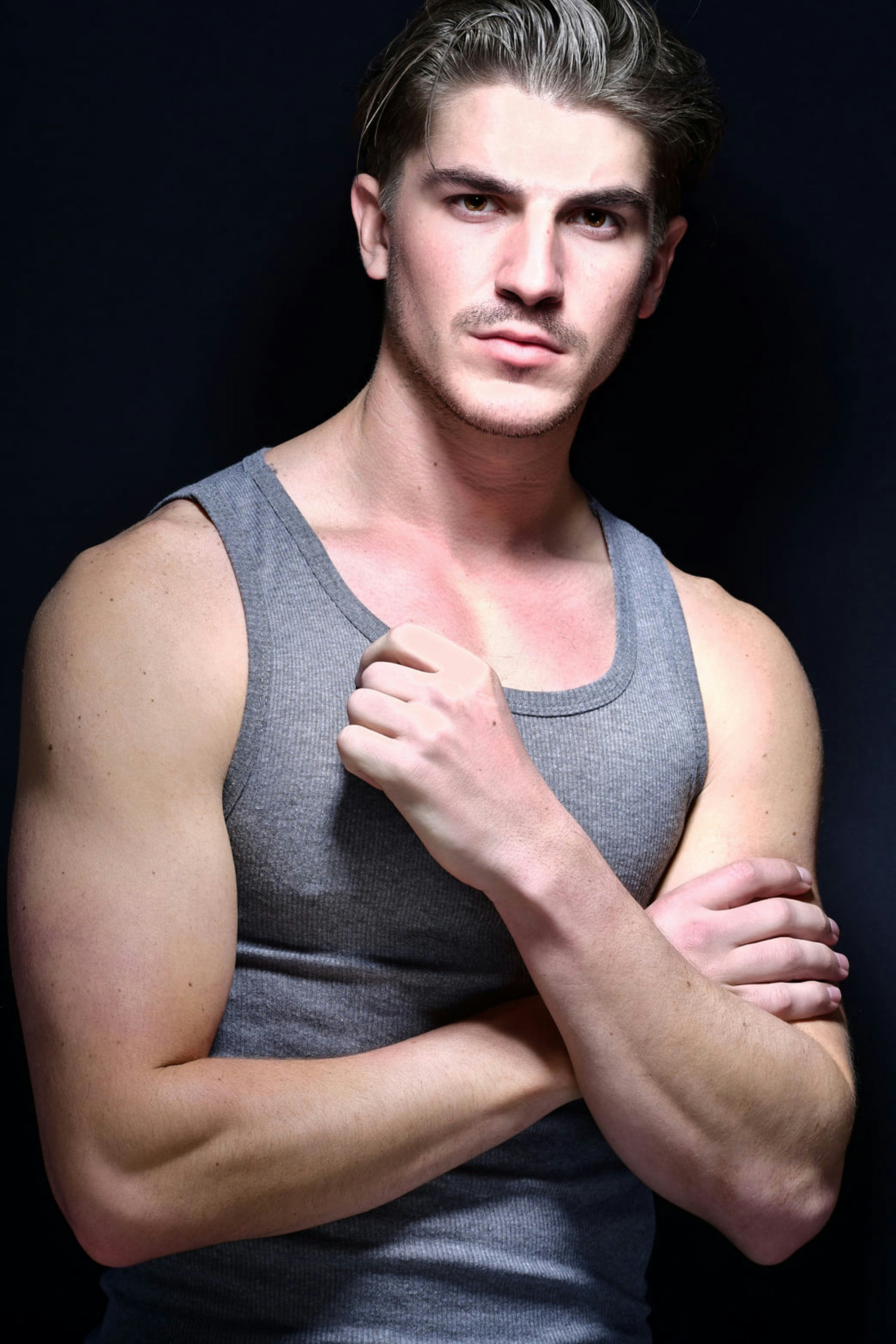 a man in a tank top posing for a picture