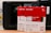 Boxes of WD Red SN700 NVMe SSDs, each with a storage capacity of 1TB, are positioned in front of a Synology NAS device. The boxes are predominantly red and white, featuring images of the SSDs and various specifications including read speed and warranty information.