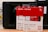 Boxes of WD Red SN700 NVMe SSDs, each with a storage capacity of 1TB, are positioned in front of a Synology NAS device. The boxes are predominantly red and white, featuring images of the SSDs and various specifications including read speed and warranty information.