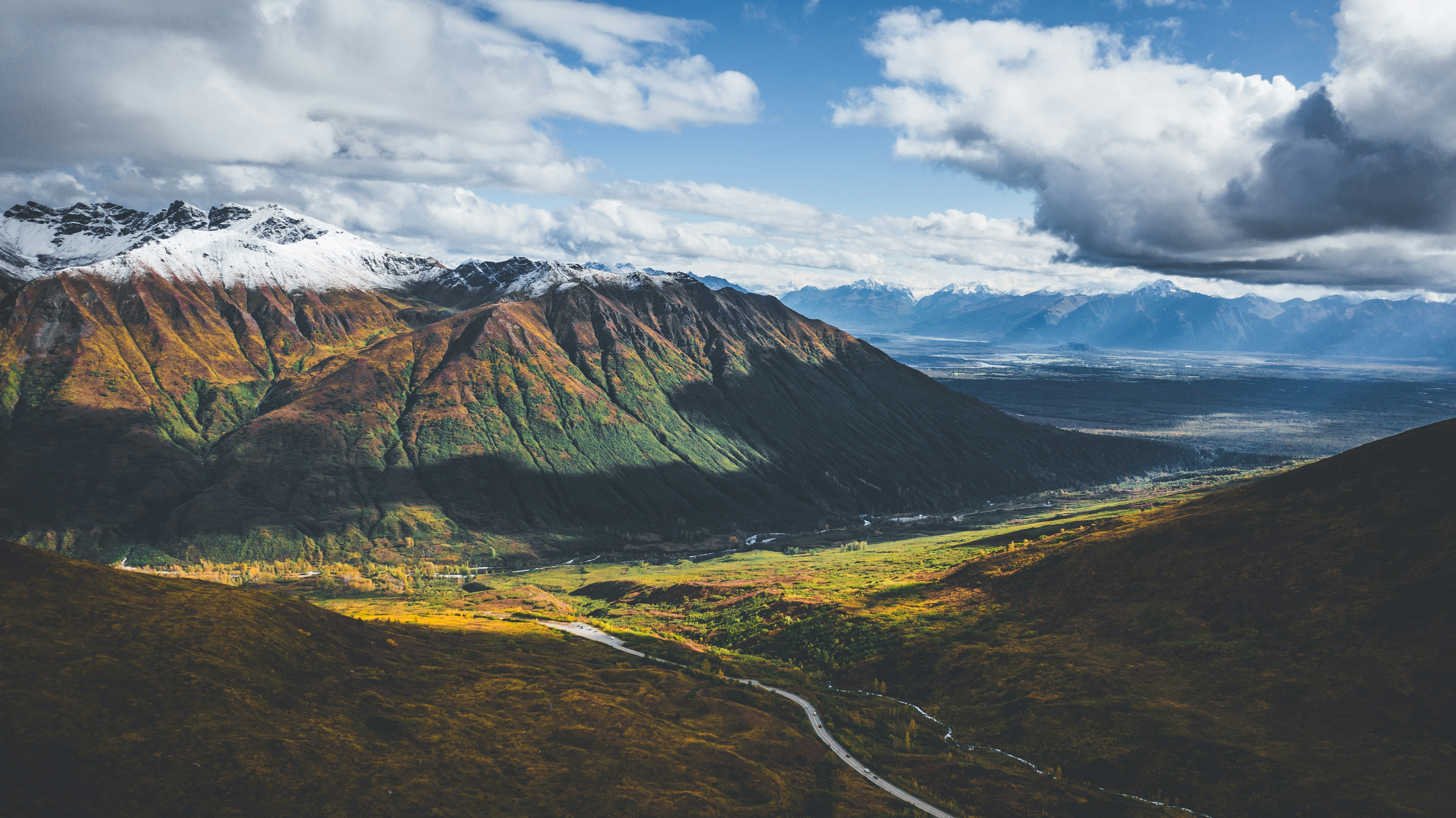 a scenic view of a valley and mountains, Drone view of the Talkeetna Mountain Range in Alaska