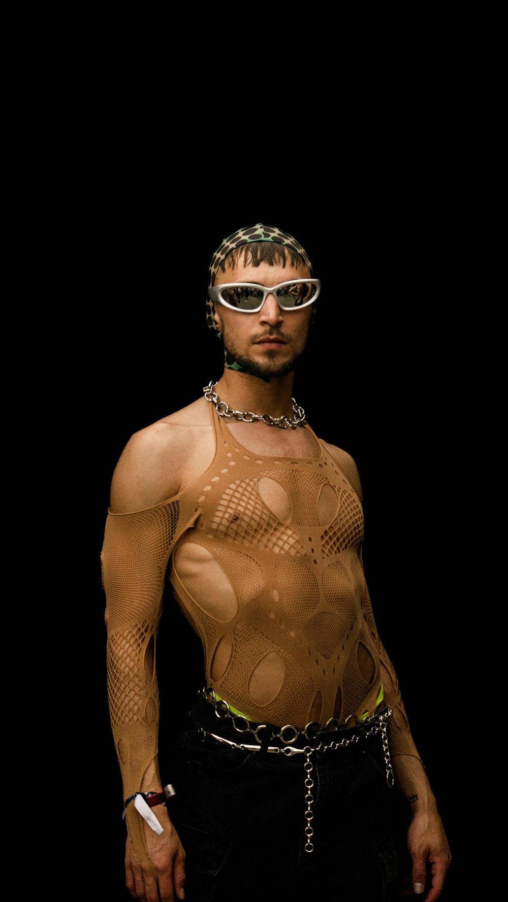 a man in a bodysuit with a chain around his neck