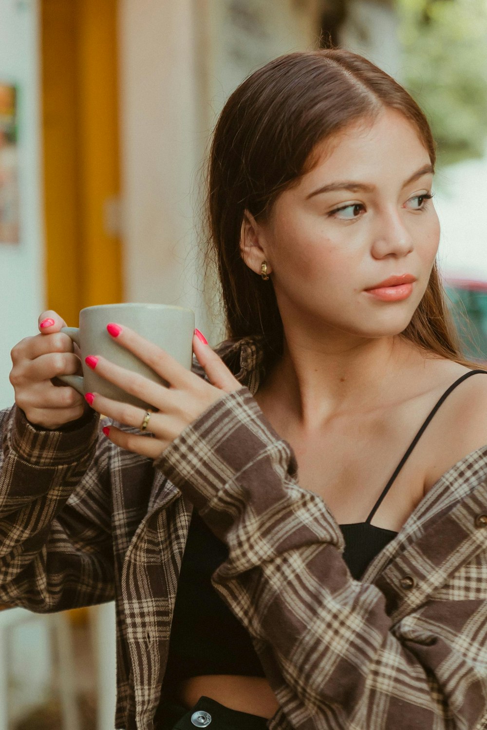 a young woman holding a cup of coffee