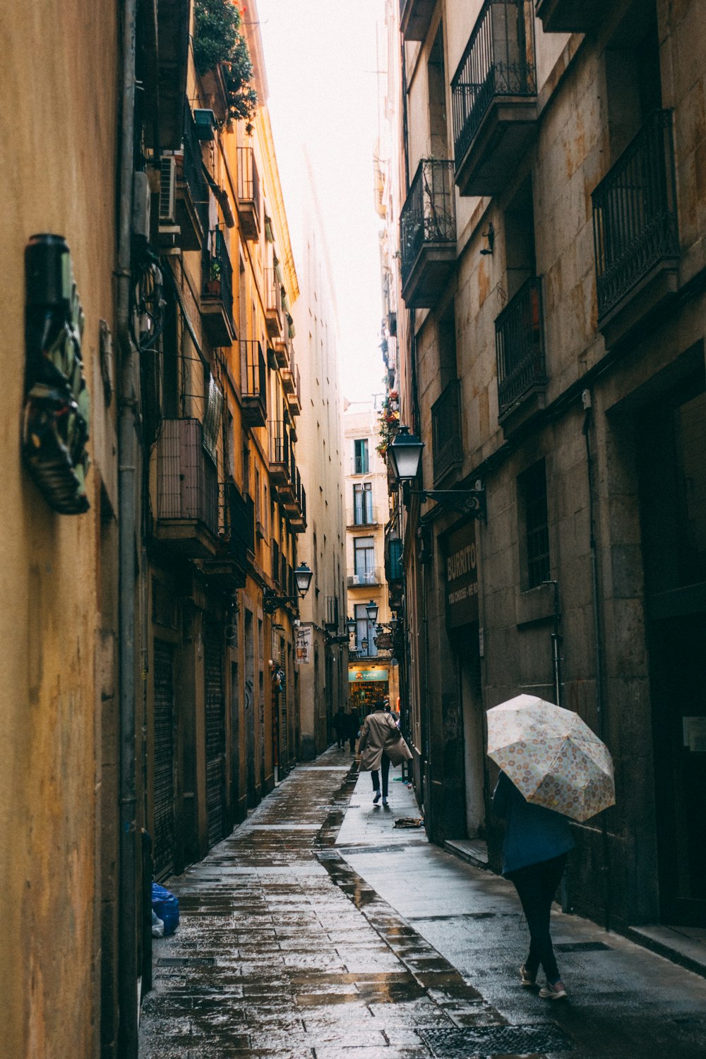 a person walking down a street holding an umbrella