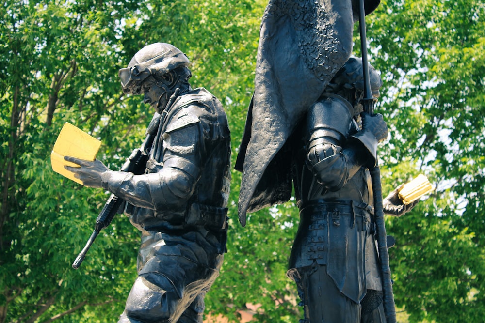 a statue of two soldiers holding a yellow folder
