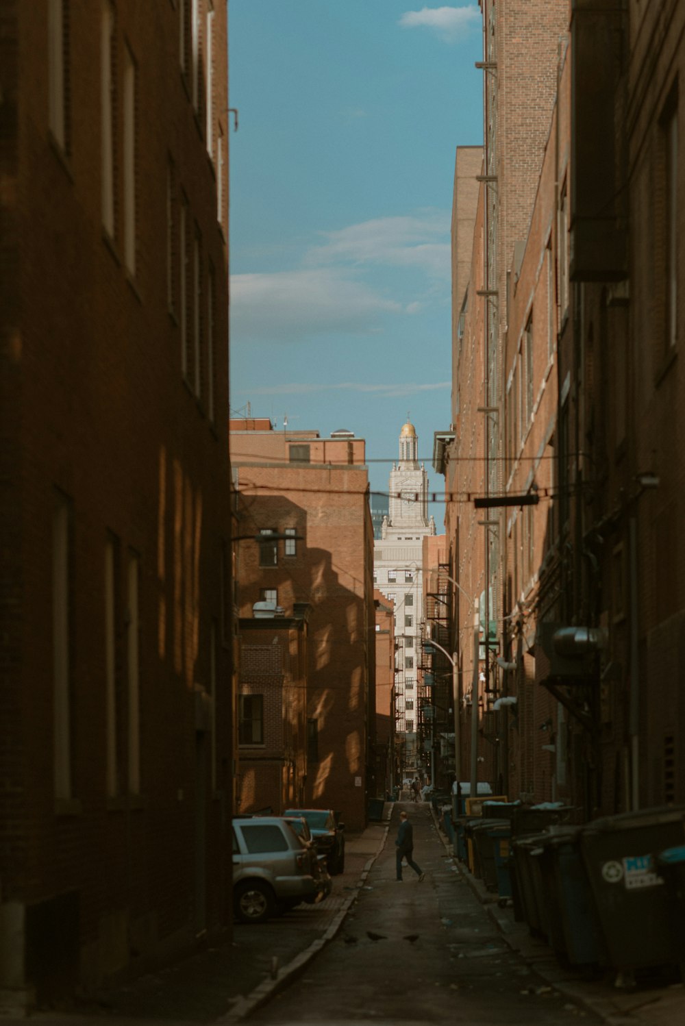 a person walking down a narrow street in a city