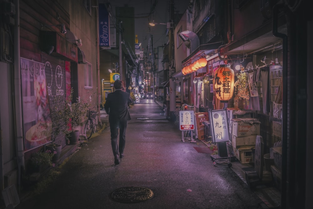 a man walking down a street at night