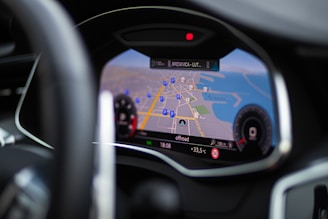 A close-up view of a car's digital dashboard displaying a navigation system. The map on the screen shows roads, parking symbols, and the temperature outside. The dashboard features sleek, modern design elements with a focus on functionality.