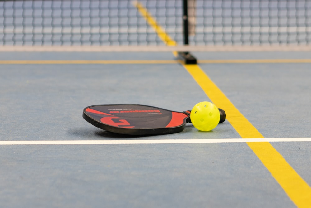 a tennis racket and ball on a tennis court