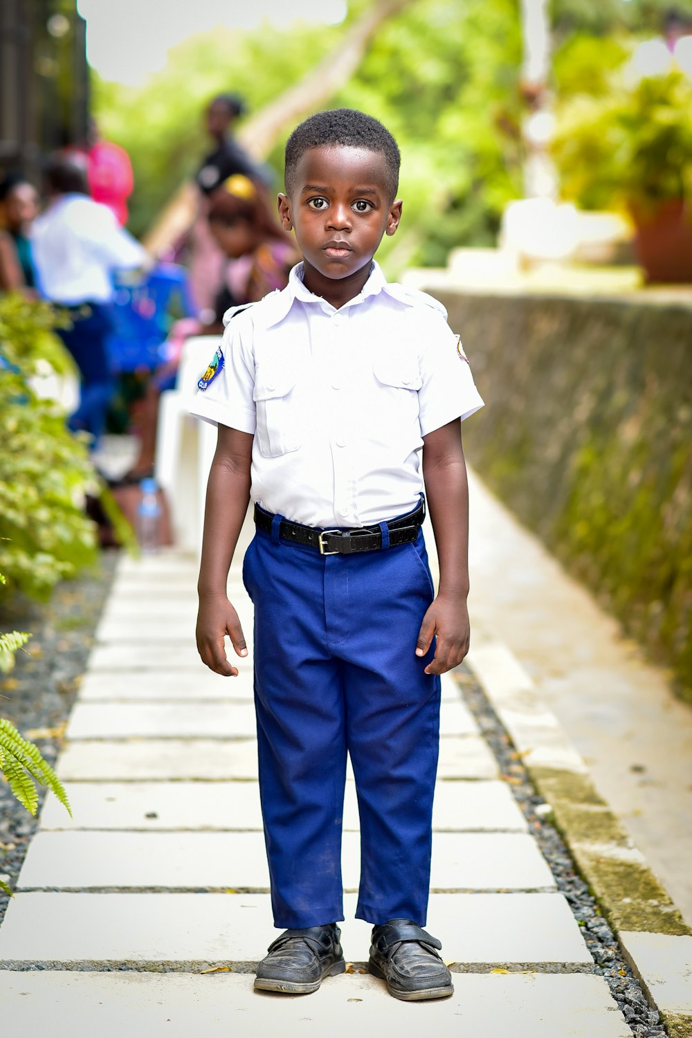 a young boy in a white shirt and blue pants