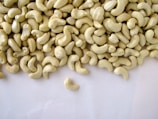 Close-up of hands sorting high-quality cashew nuts on a wooden table.
