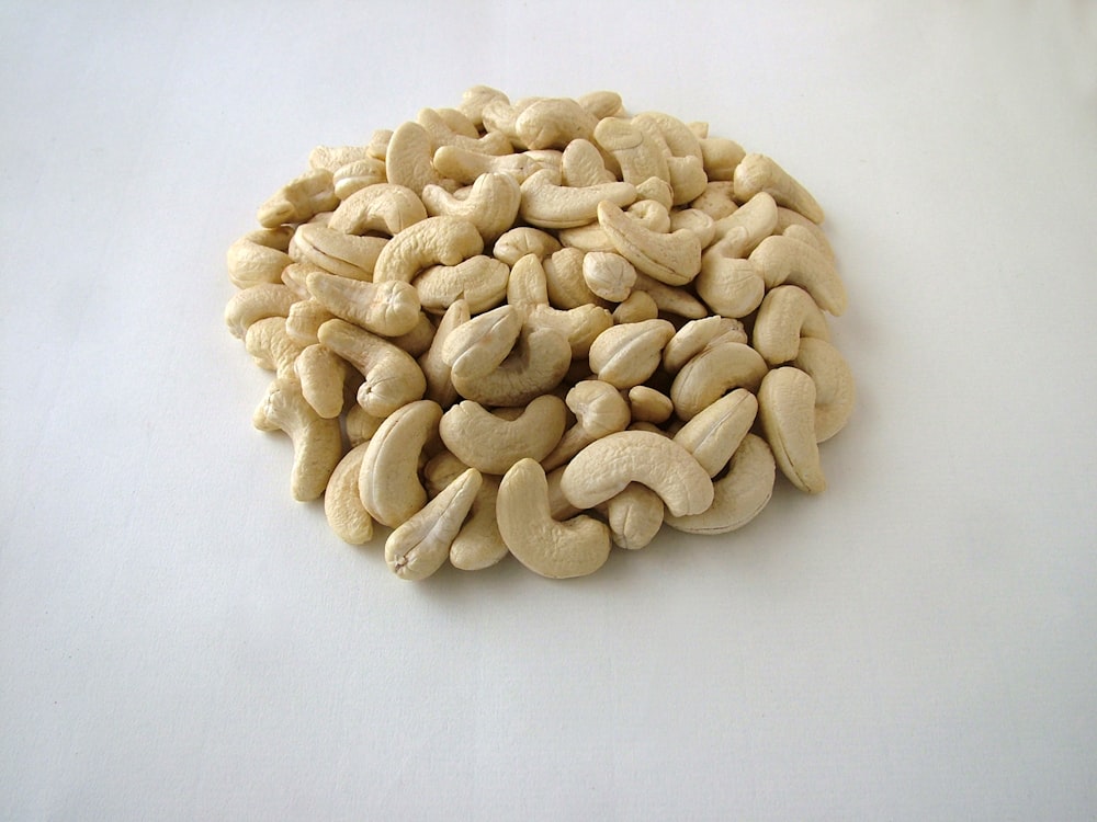 a pile of cashews sitting on top of a white table