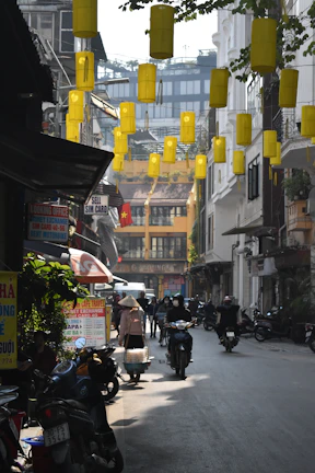 Traveler using a smartphone with VietLynk SIM card in a bustling Hanoi street market.