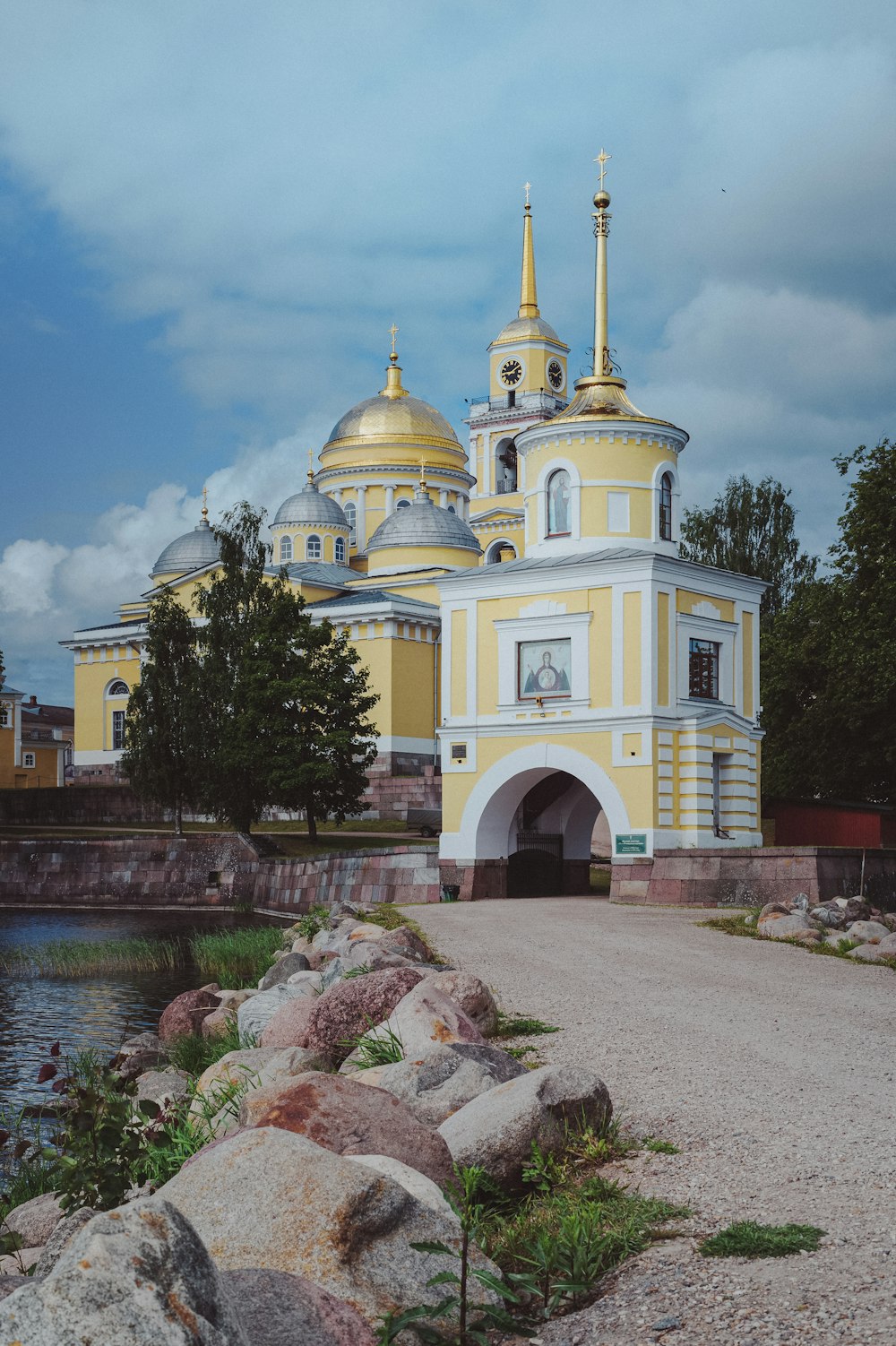 a large yellow and white building sitting next to a body of water