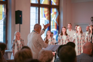 a group of people standing in front of a stained glass window