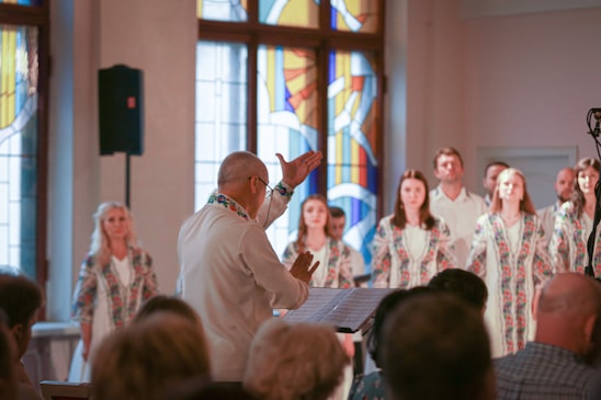 a group of people standing in front of a stained glass window