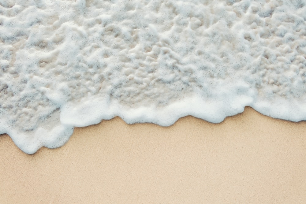 a close up of a wave on a sandy beach