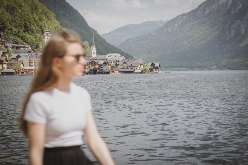 a woman standing in front of a body of water