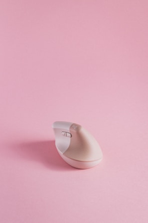 a computer mouse sitting on top of a pink surface