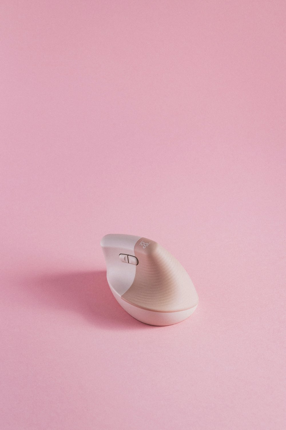 um mouse de computador sentado em cima de uma superfície rosa