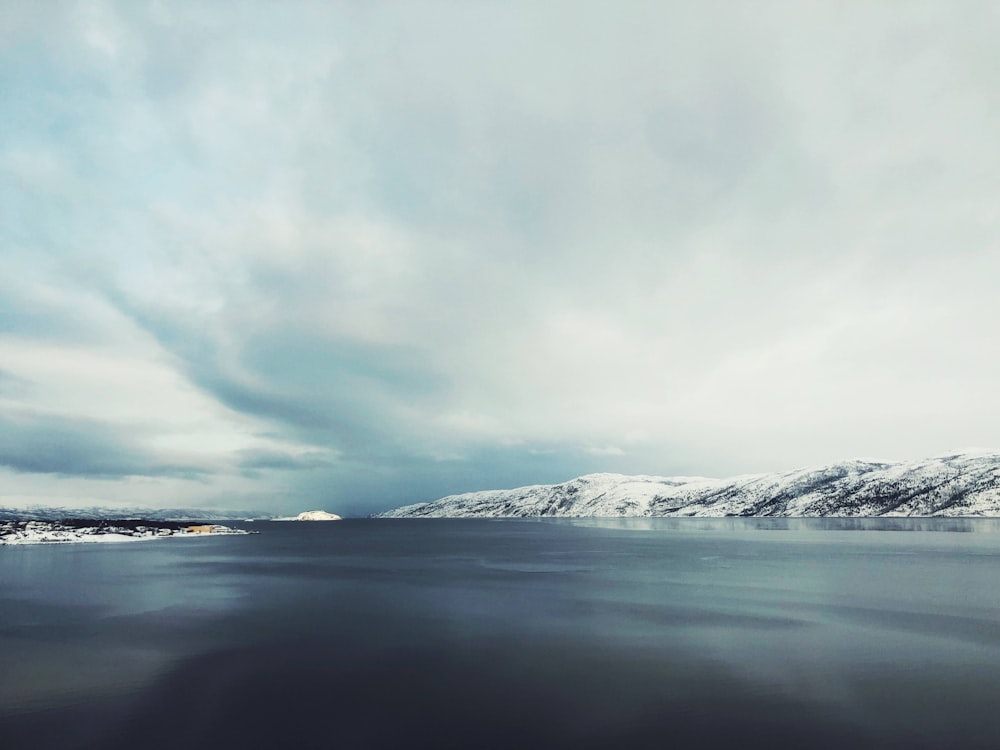 a large body of water surrounded by snow covered mountains