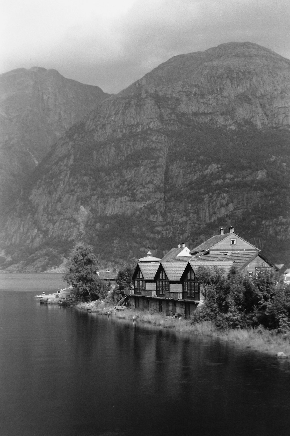 a black and white photo of a house by the water