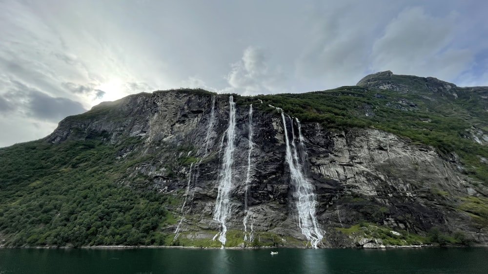 a large waterfall is on the side of a mountain