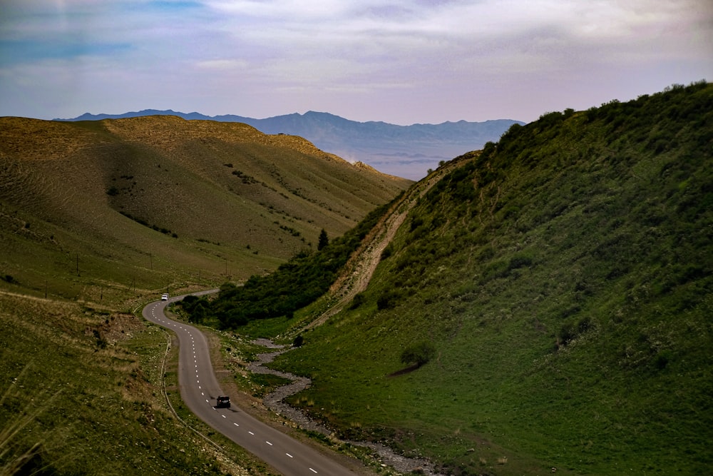 a car driving down a winding road in the mountains