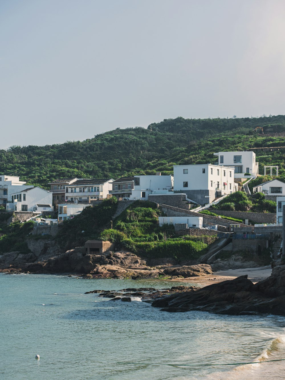 a beach with houses on a hill in the background