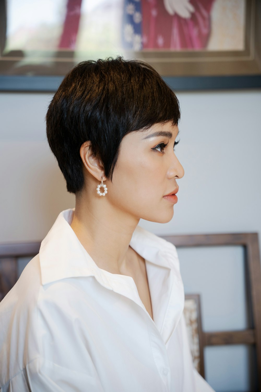 a woman with short hair wearing a white shirt