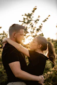 A serene outdoor portrait of a couple embracing at golden hour.