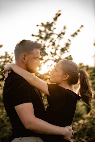 A joyful couple embracing during a golden hour photo session outdoors.