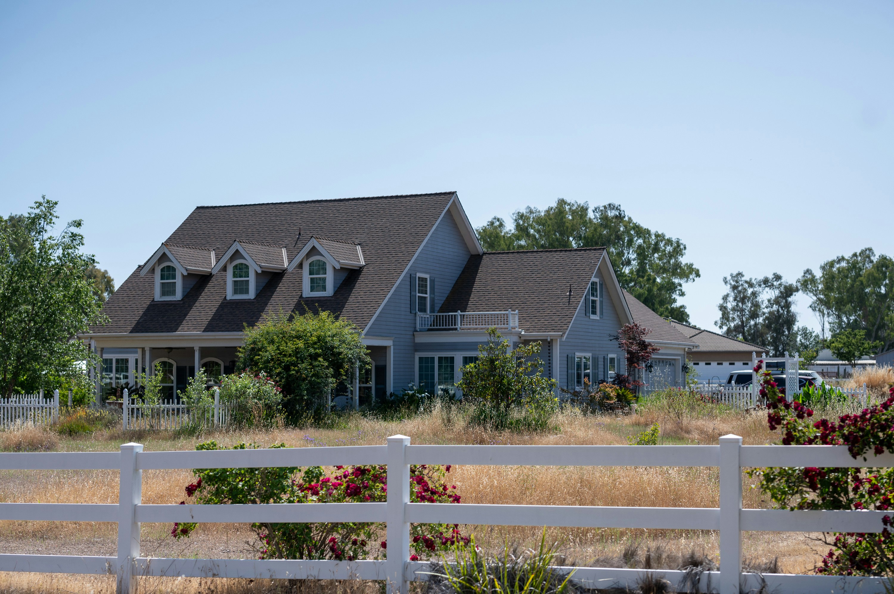 a large house with a white fence in front of it