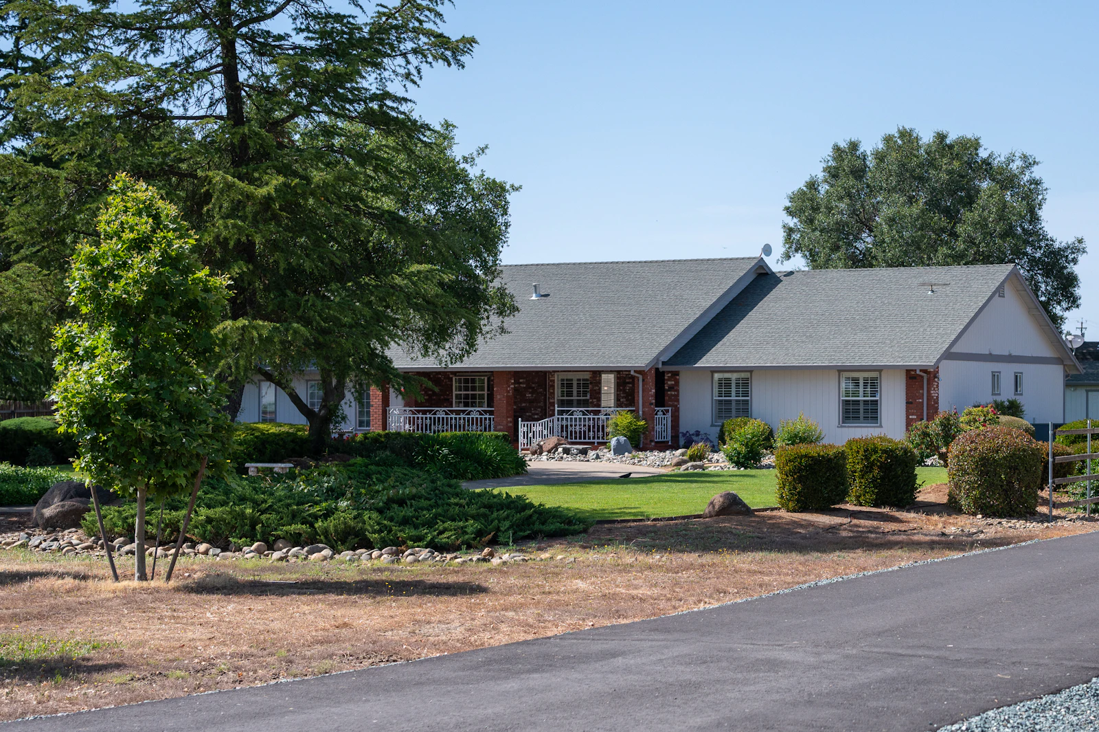 A ranch house set back under mature trees.