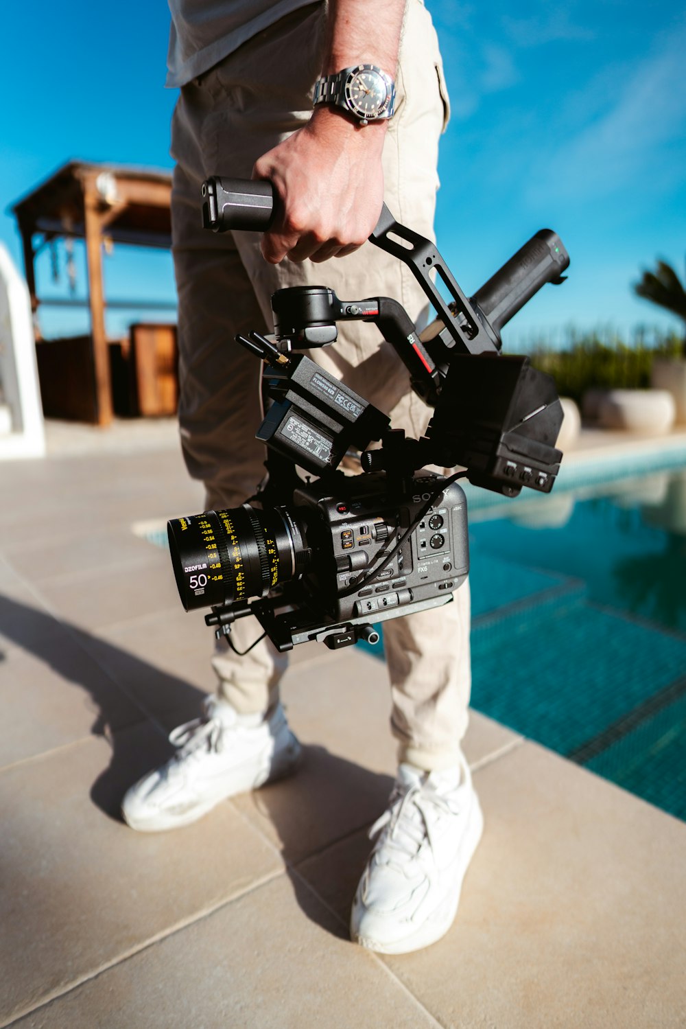 a man standing next to a pool holding a camera