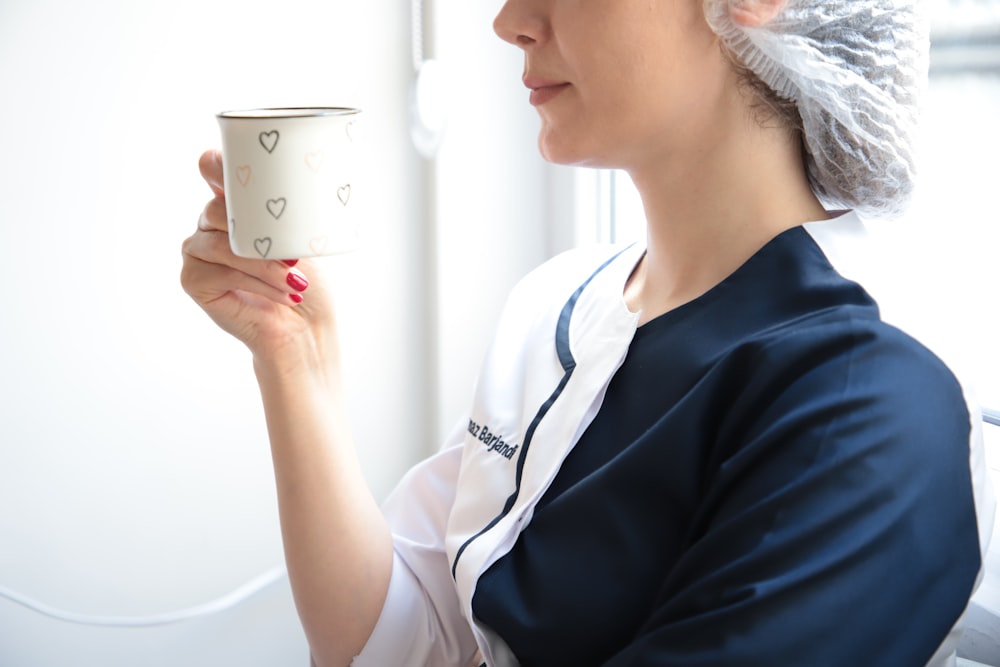 a woman holding a cup in her right hand