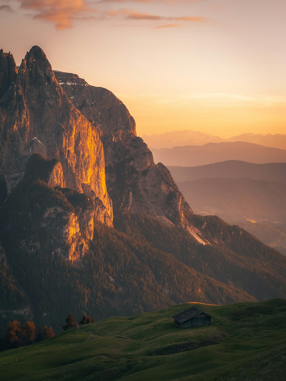 a view of a mountain range with a house in the foreground