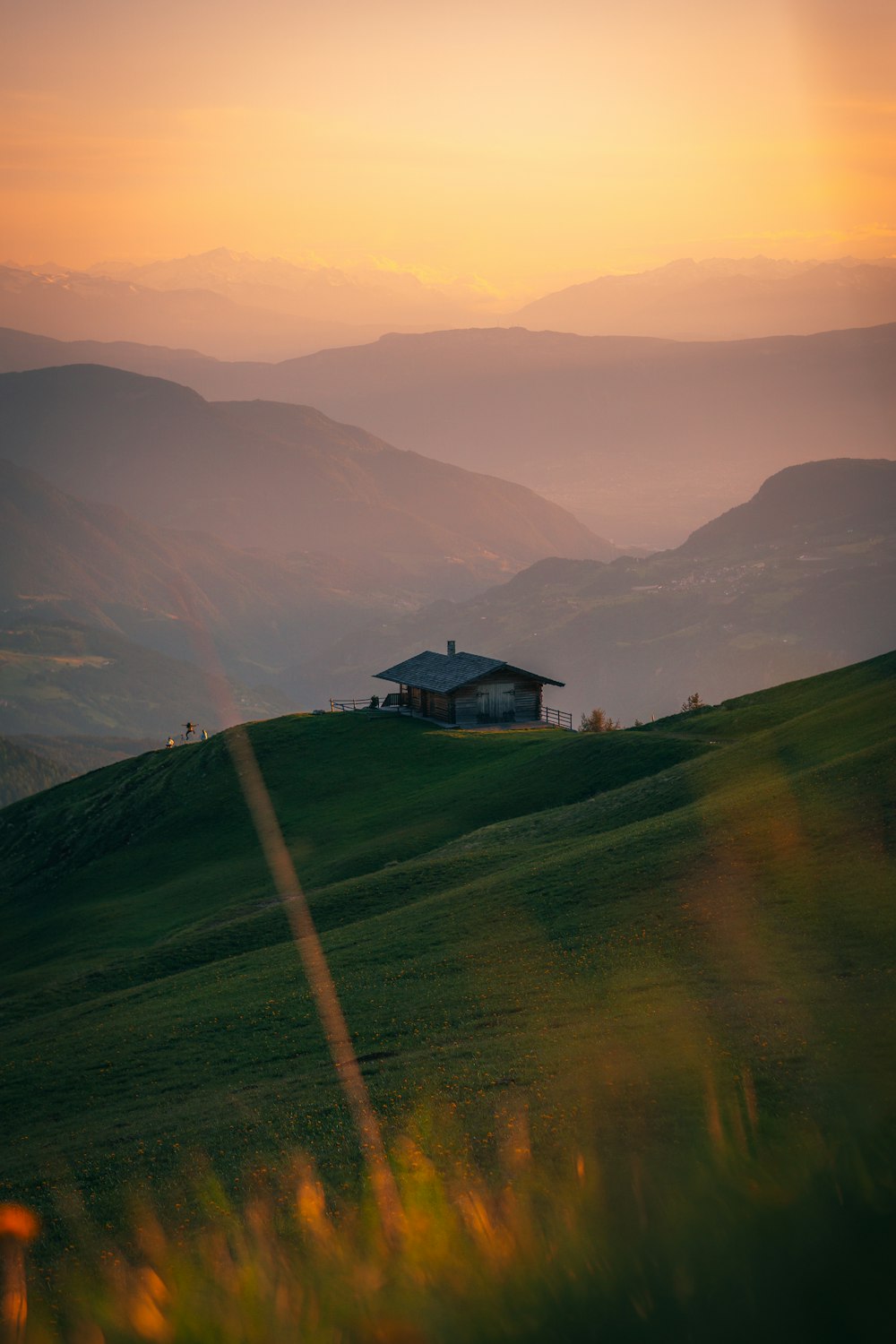 Una casa sulla cima di una collina con le montagne sullo sfondo