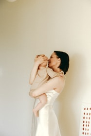 A mother gently holding her child in a cozy, welcoming space filled with handmade crafts.