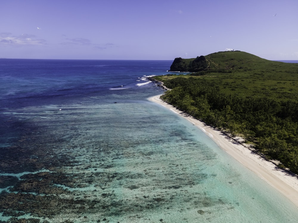 an aerial view of a beach with a boat in the water