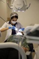 a person in a dentist chair with a mask on