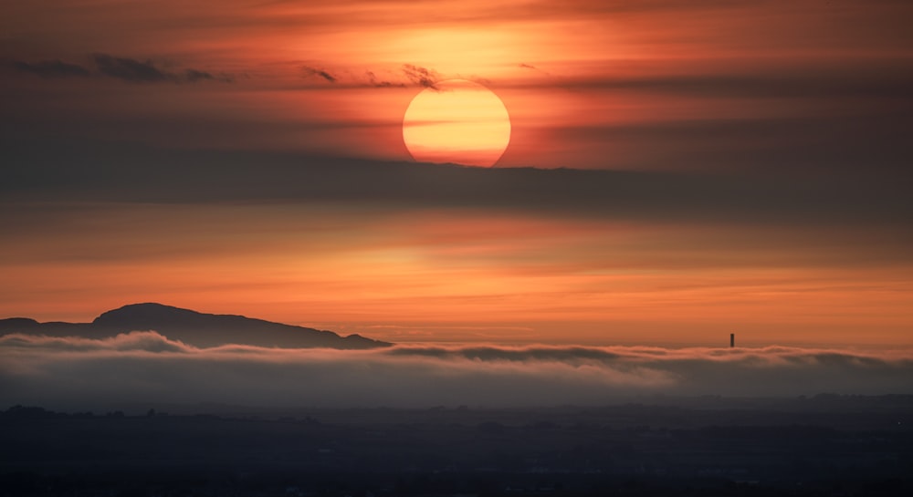 the sun is setting over the clouds in the sky