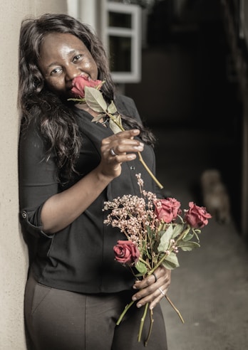 a woman holding a bunch of flowers in her hands