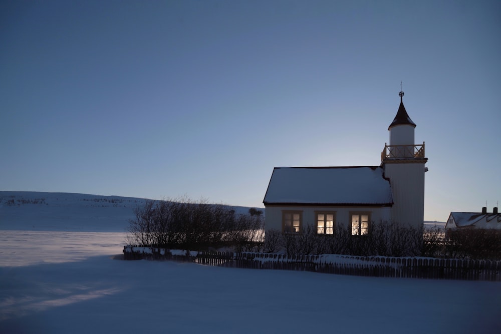 a small church with a steeple in the snow