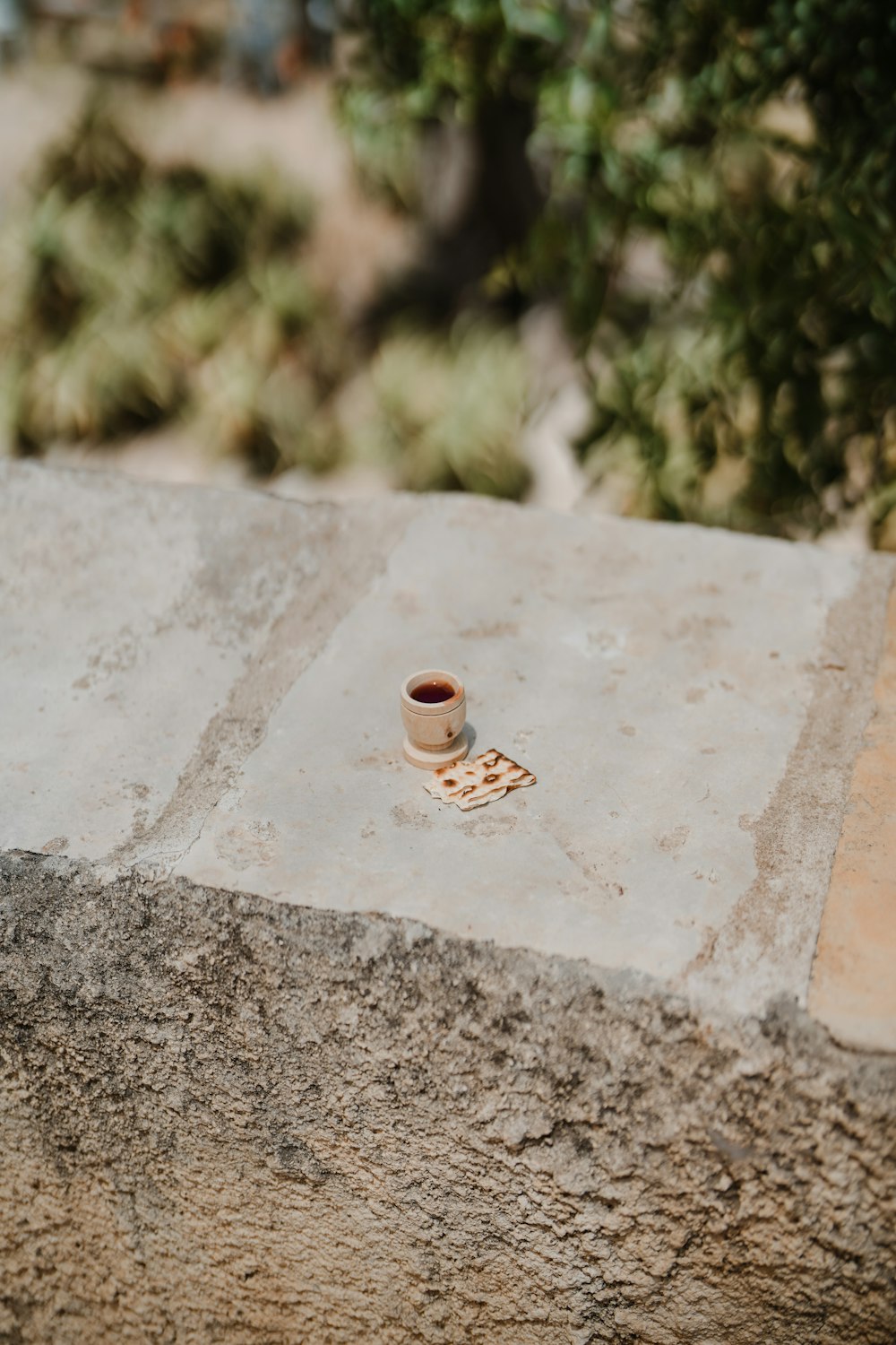 a cup of coffee sitting on top of a cement slab