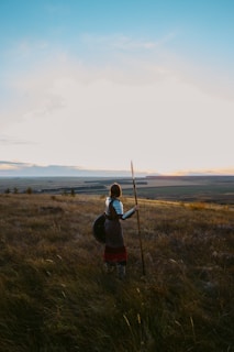 a person with a backpack and a stick in a field