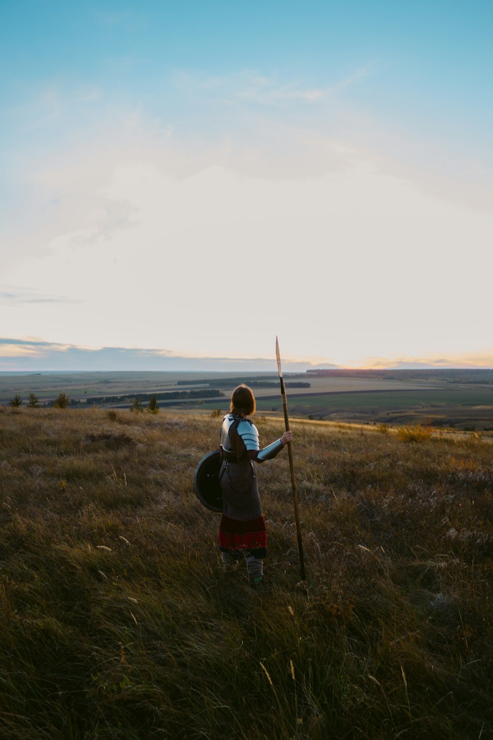 a person with a backpack and a stick in a field