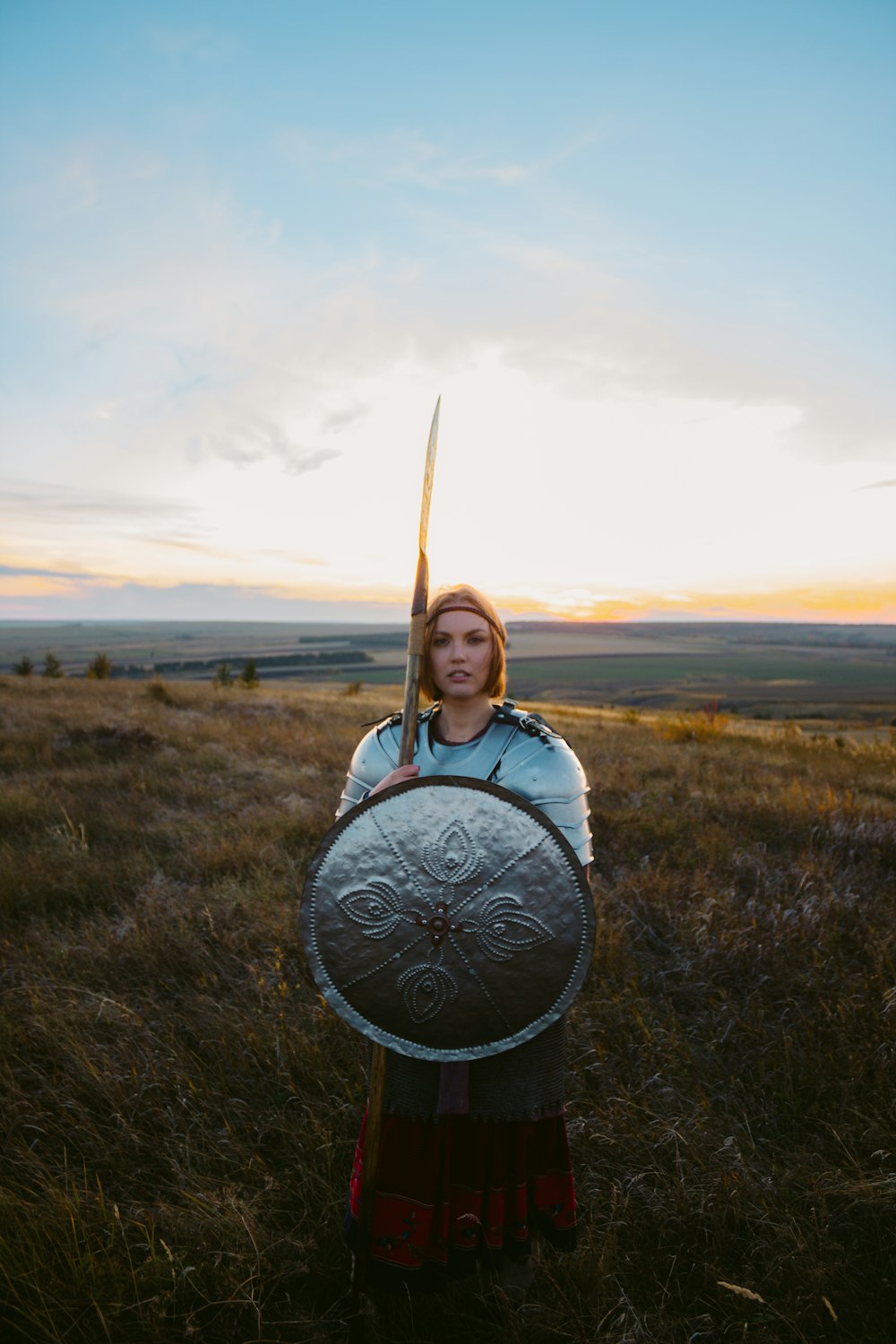 野原で剣と盾を持つ女性