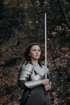 a woman dressed in armor holding a sword
