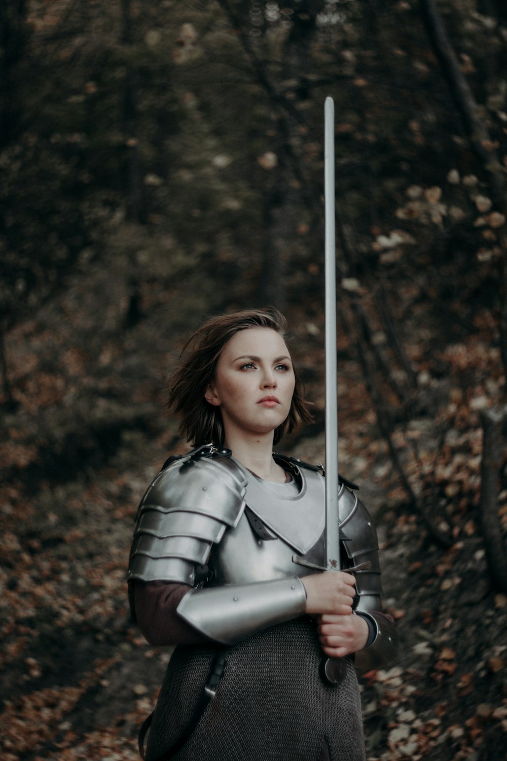 a woman dressed in armor holding a sword